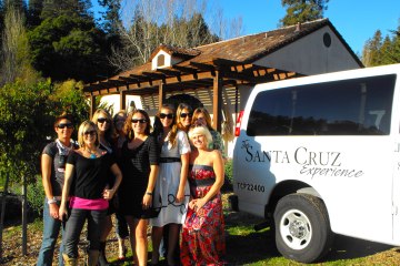 Wine tour participants posing near shuttle van